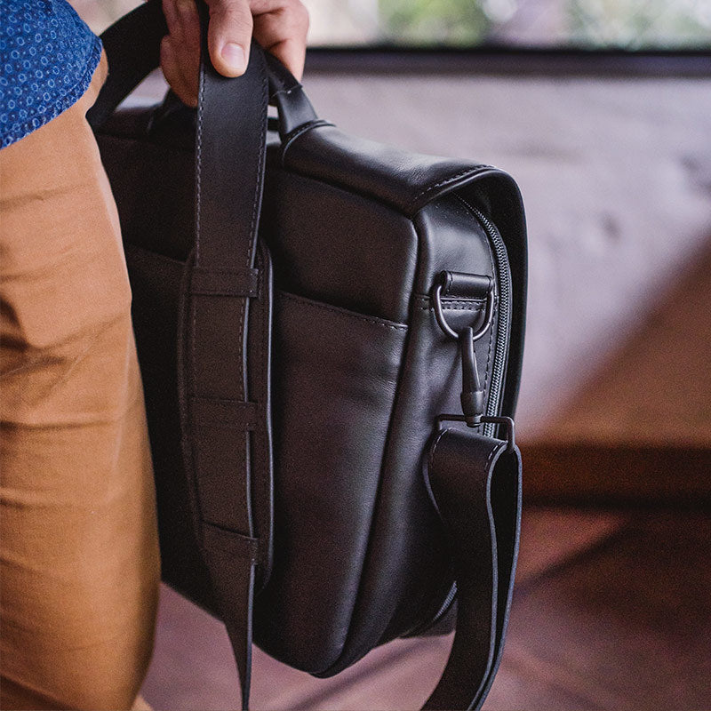 Nordweg black leather messenger briefcase side strap, zipper, and hardware close-up