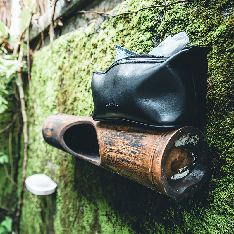 Nordweg green leather bag on grass outdoors in a close lifestyle detail