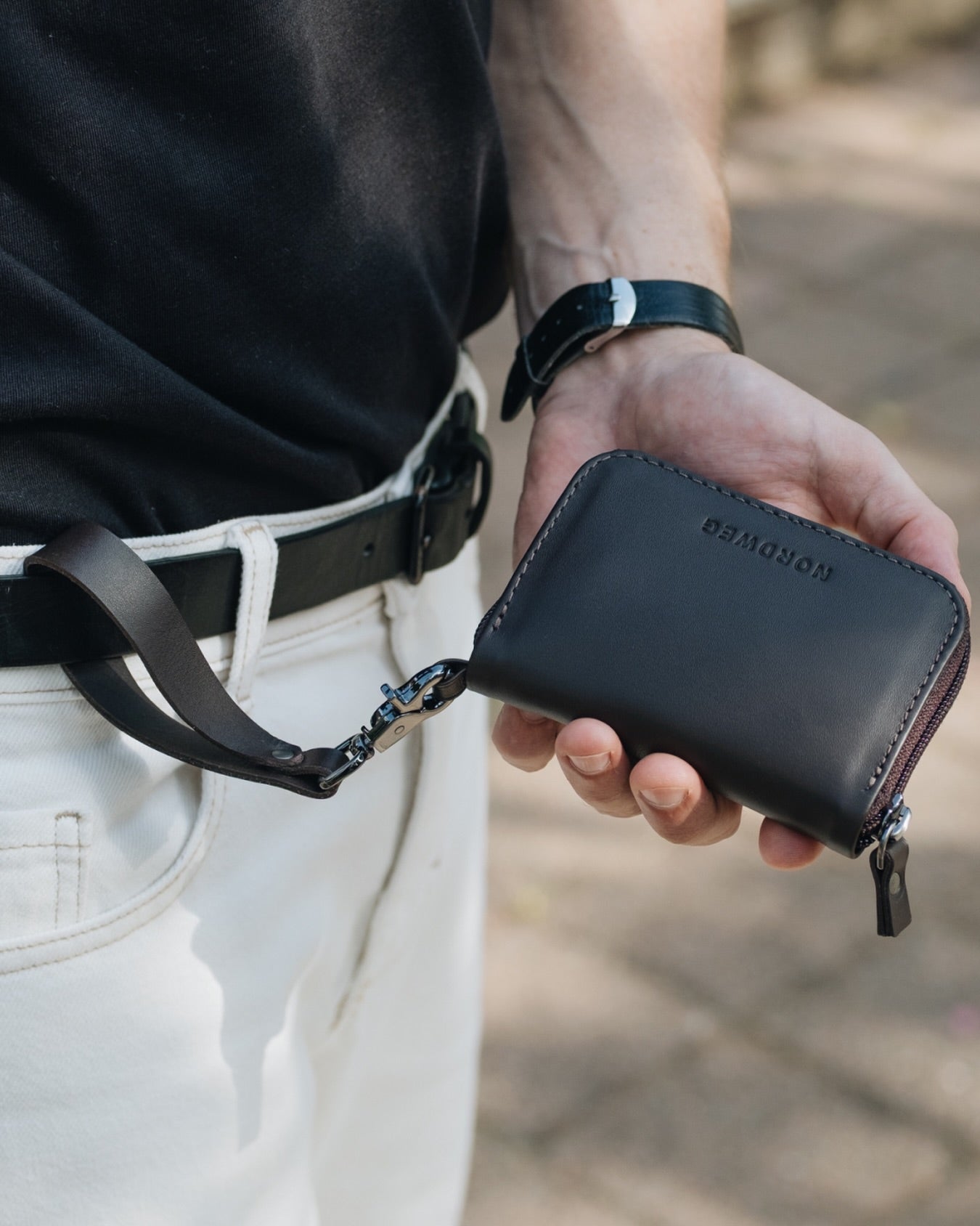 Nordweg Nomad leather passport wallet in black, front view with zip-around closure