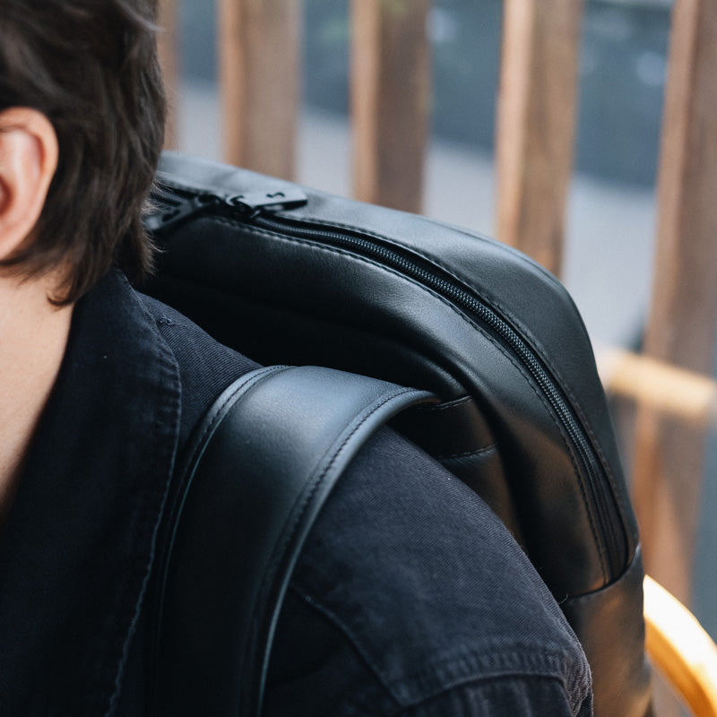 Nordweg black leather backpack shoulder strap and top zipper close-up in a lifestyle setting