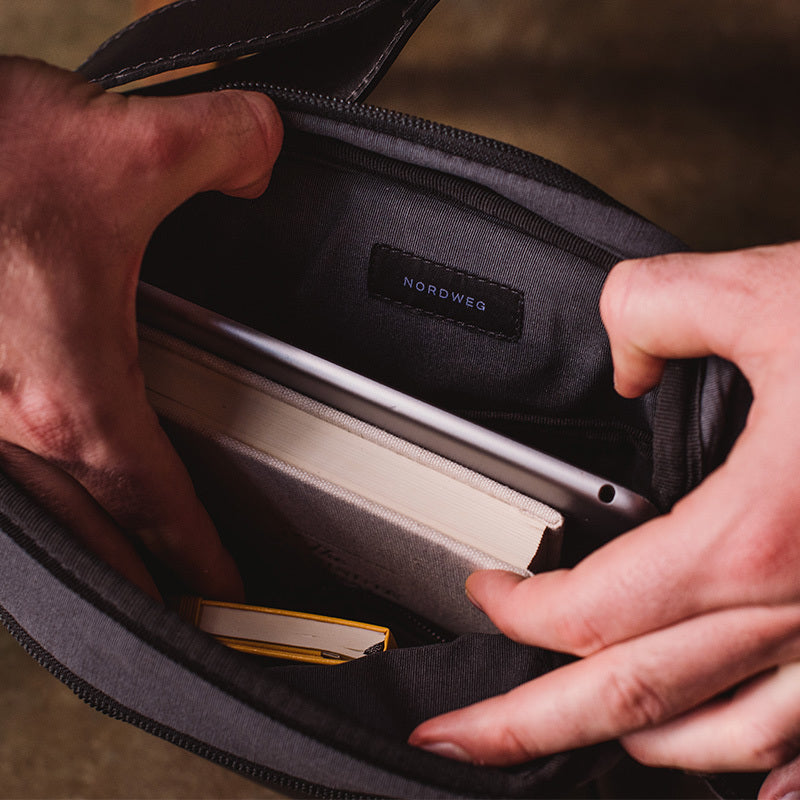 Nordweg black leather bag front pocket opened by hand in a close product detail