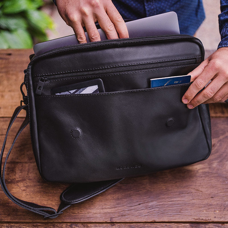 Nordweg black leather messenger briefcase open with laptop, passport, and front pocket detail