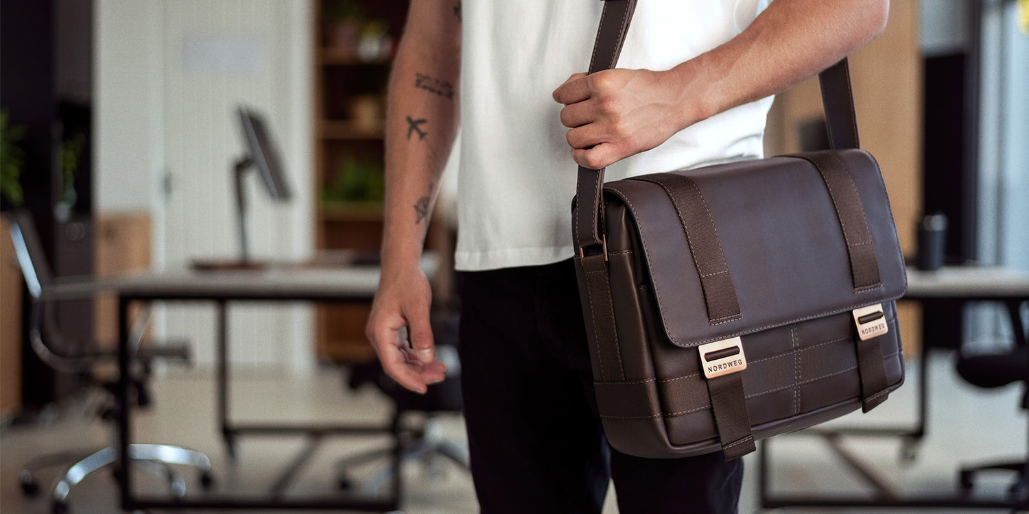 Nordweg brown leather camera shoulder bag carried in an office lifestyle photo