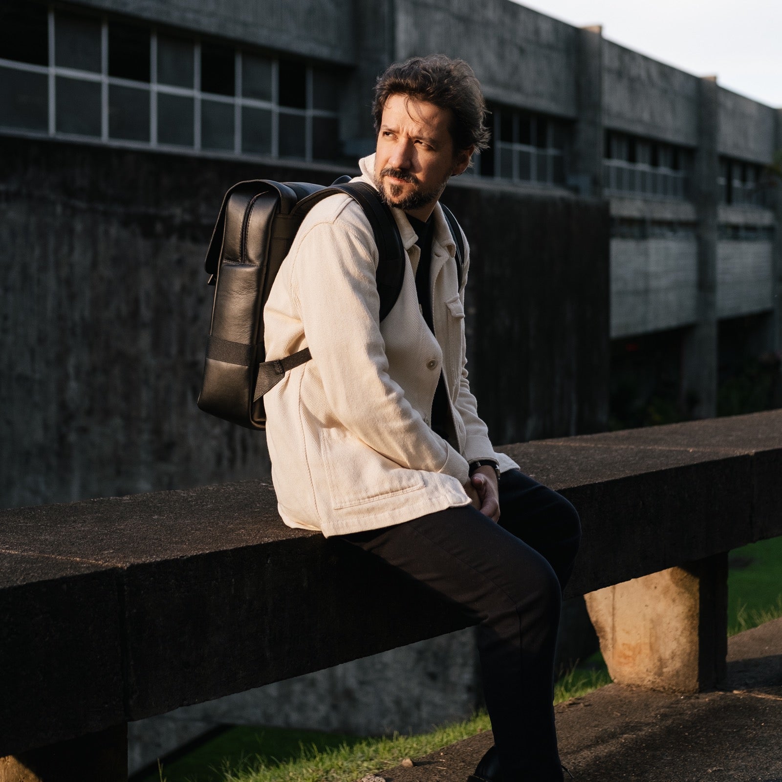 Black Dolomites Travel Backpack worn outside a modern concrete building
