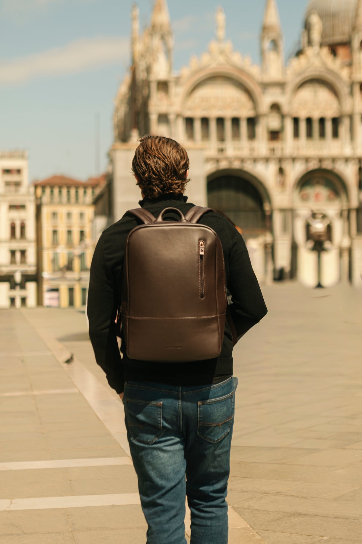 Brown Nordweg Nomad backpack worn in a sunlit city square