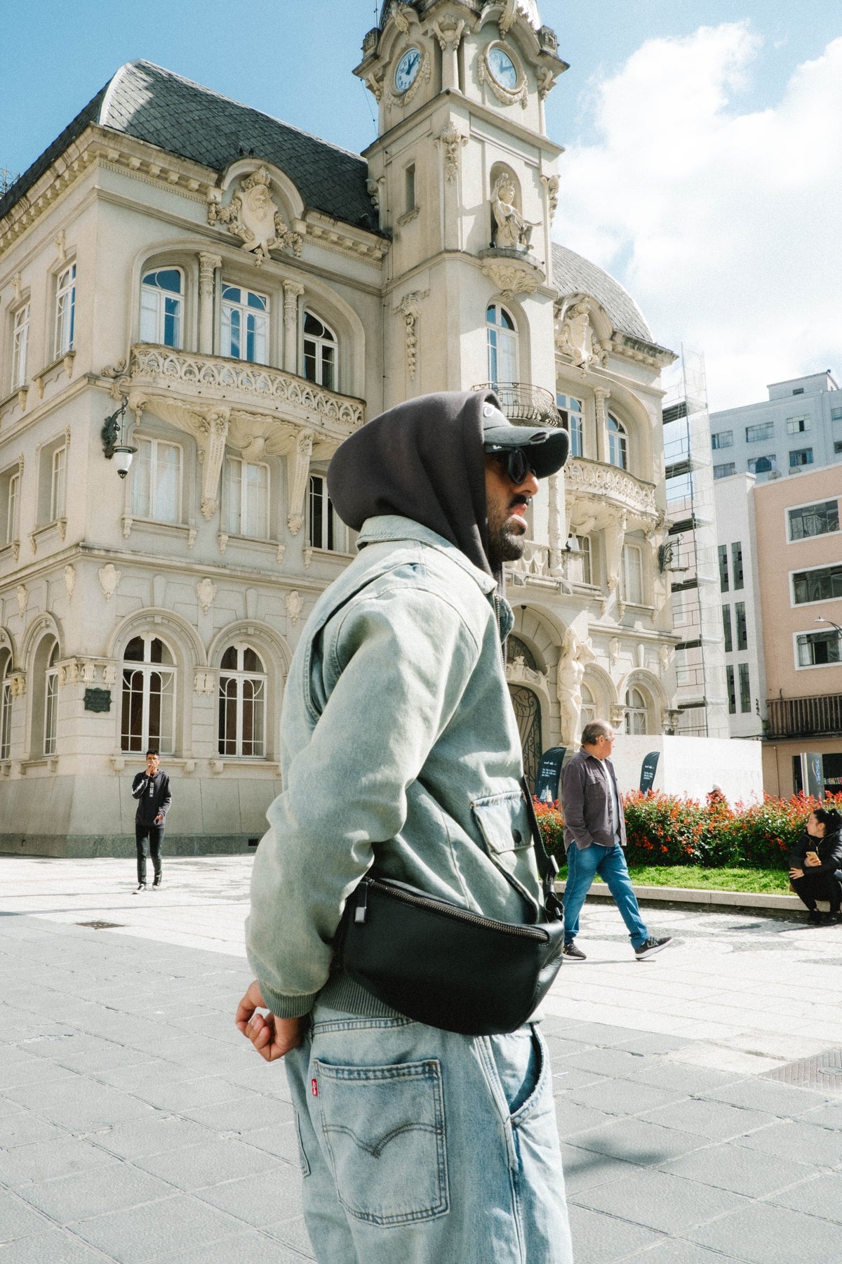 Black Nordweg Pulse sling bag worn with a light denim jacket in a city square
