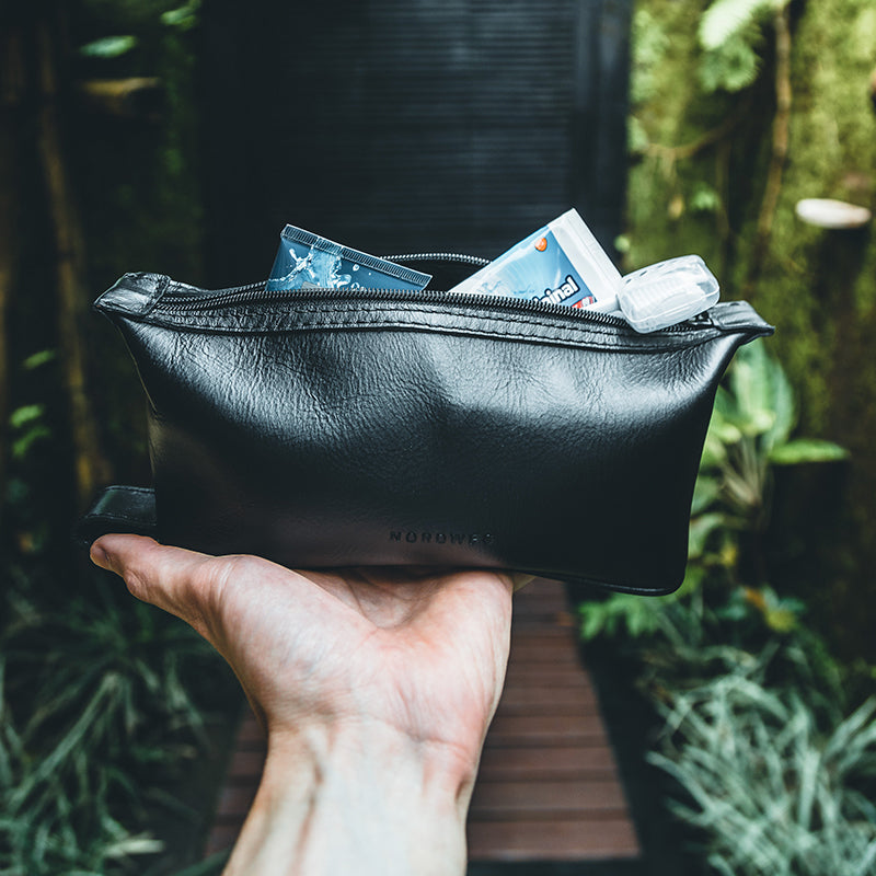 Nordweg green leather folded pouch held by hand outdoors in a product detail photo