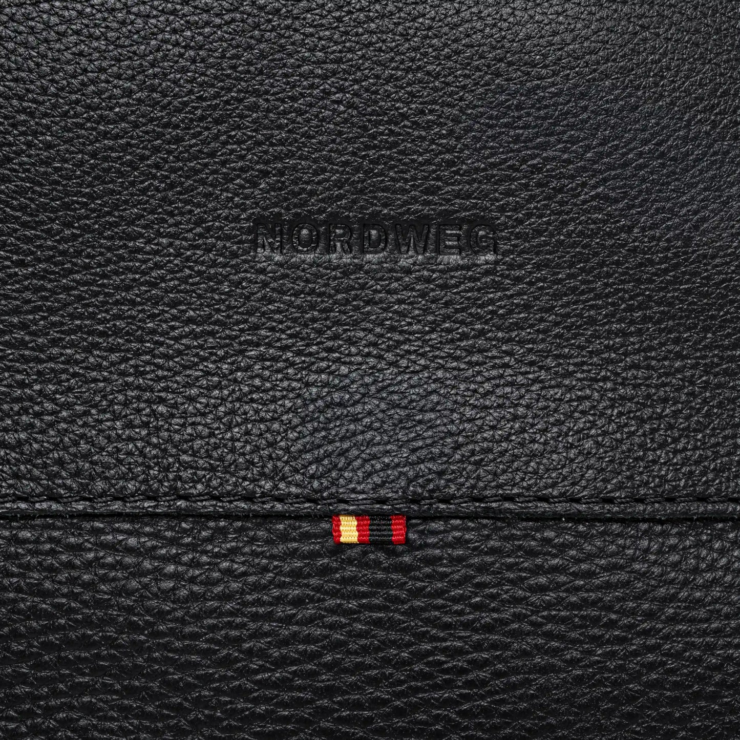 Close-up of Nordweg logo on coal pebbled leather backpack
