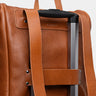 Cognac Legacy leather backpack luggage pass-through on a rolling suitcase handle
