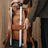 Nordweg Legacy Leather Backpack in cognac leather attached to luggage trolley handle via back sleeve