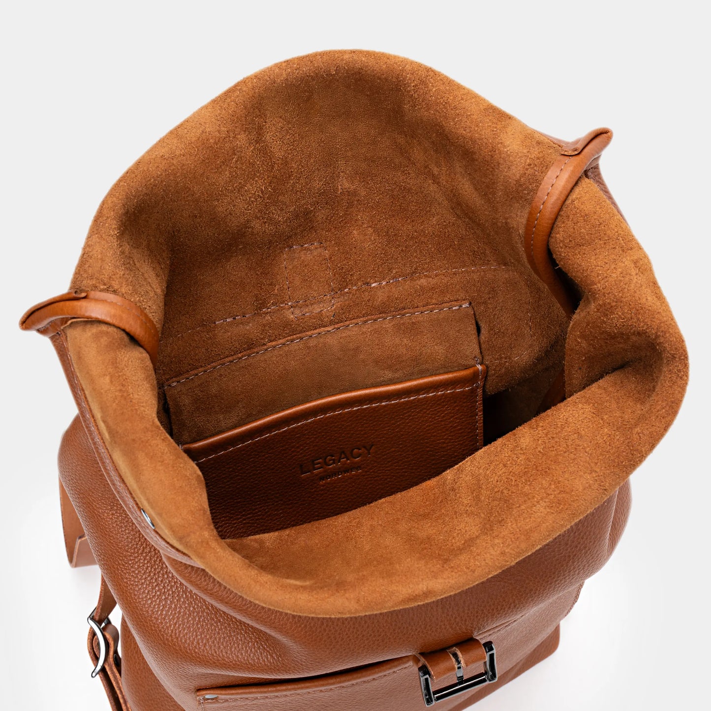 Open cognac Legacy leather backpack showing top interior and leather pocket