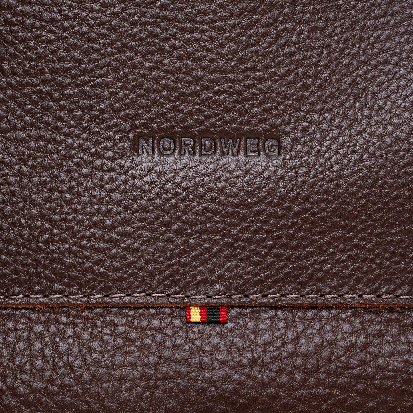 Close-up of Nordweg logo on espresso pebbled leather backpack