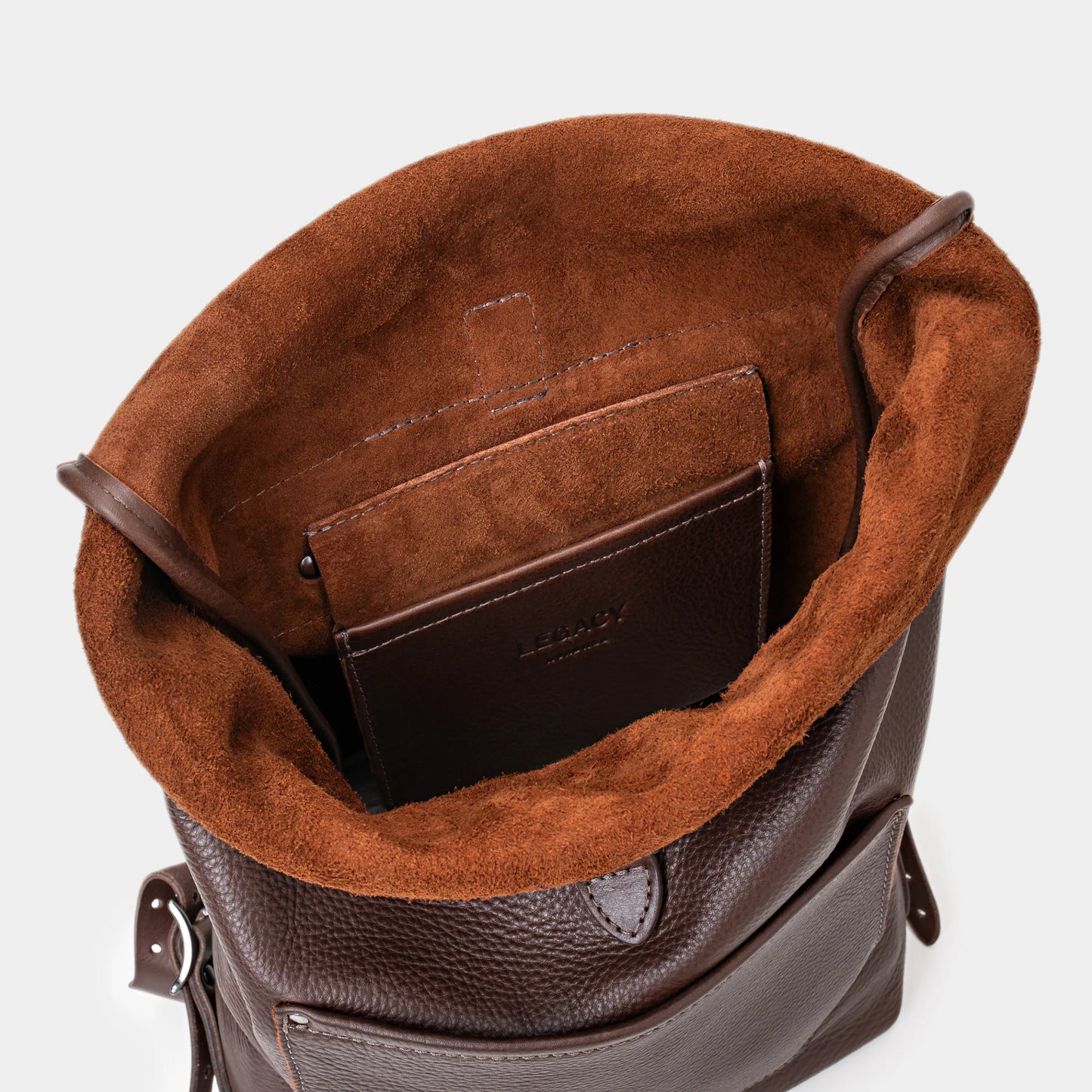 Open espresso Legacy leather backpack showing top interior and leather pocket