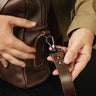 Close-up of the metal swivel hook attaching the shoulder strap to the Nordweg Legacy Leather Briefcase in espresso