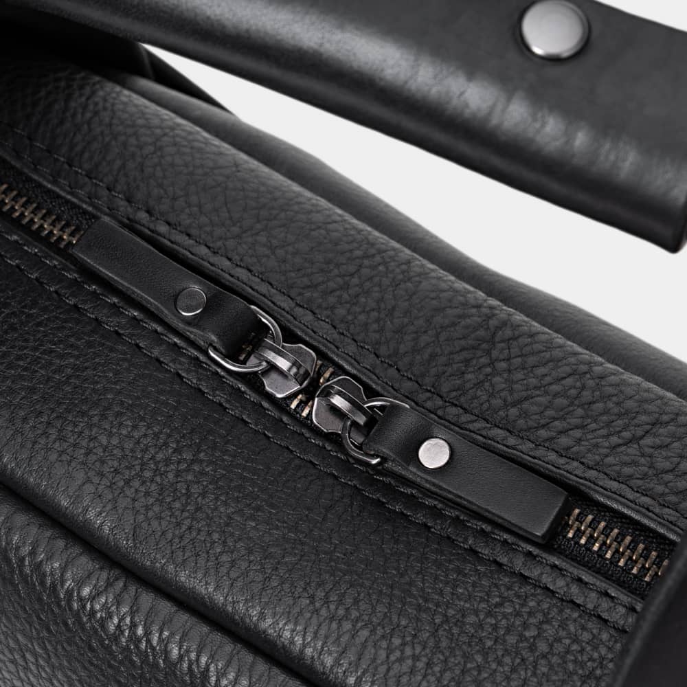Close-up of coal Legacy leather briefcase top zipper pulls