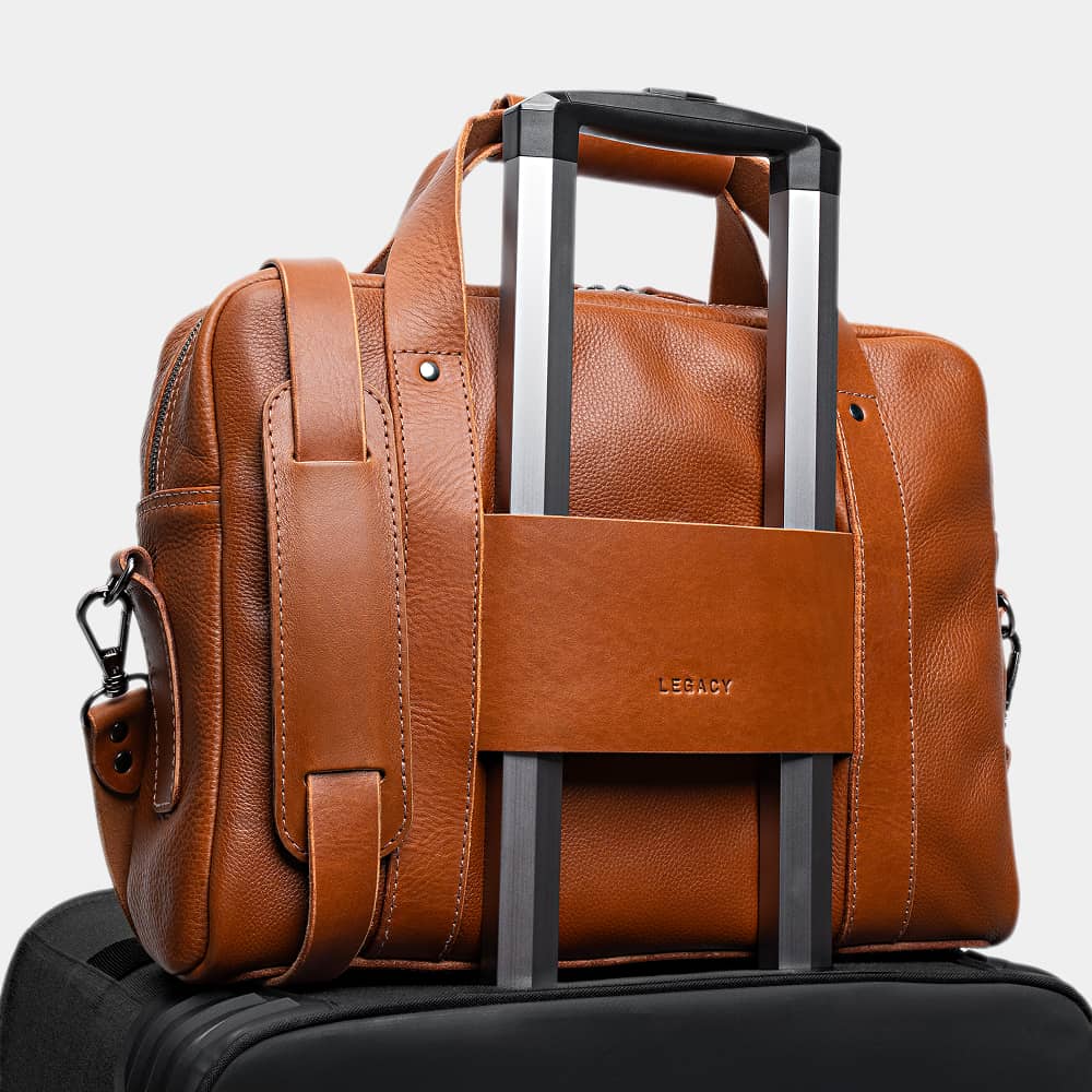 Cognac Legacy leather briefcase luggage pass-through on a rolling suitcase handle