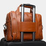 Cognac Legacy leather briefcase luggage pass-through on a rolling suitcase handle