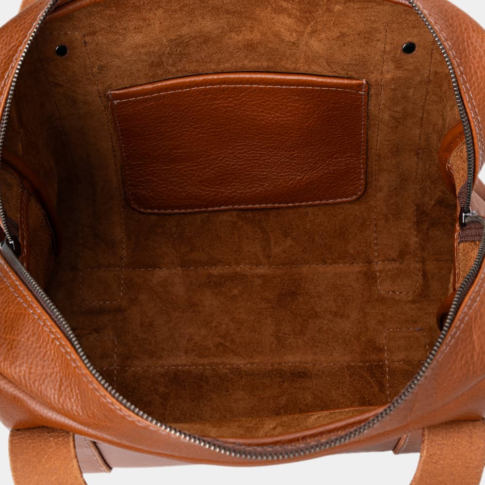 Open cognac Legacy leather briefcase showing interior pocket