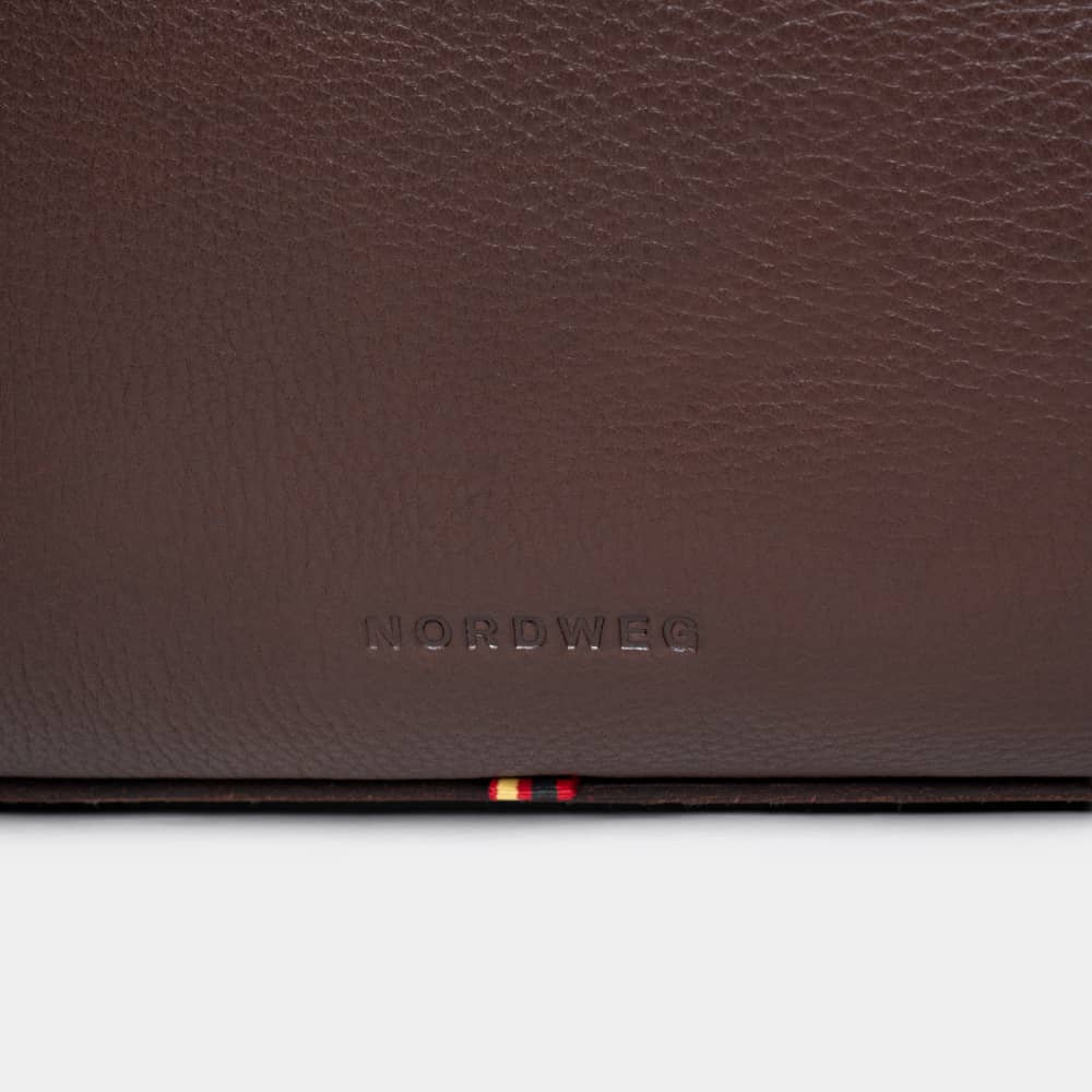 Close-up of Nordweg logo on espresso pebbled leather briefcase