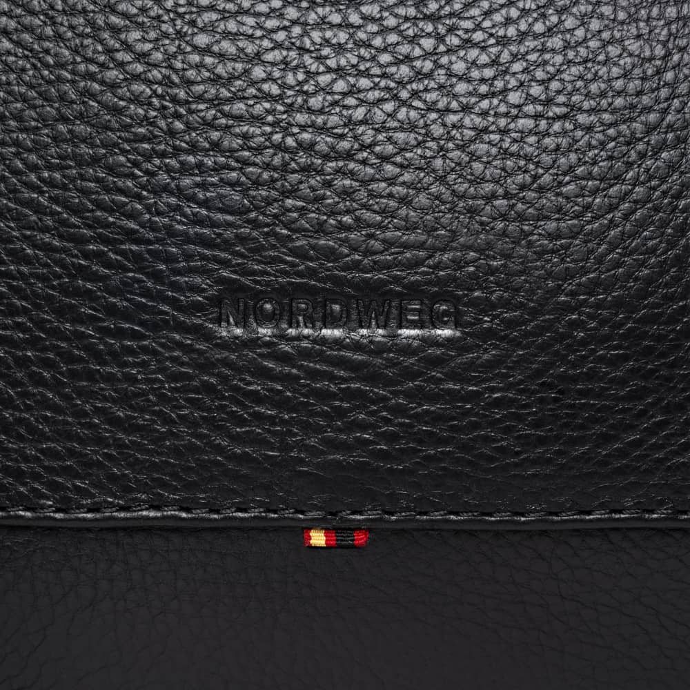 Close-up of Nordweg logo on coal pebbled leather duffel bag