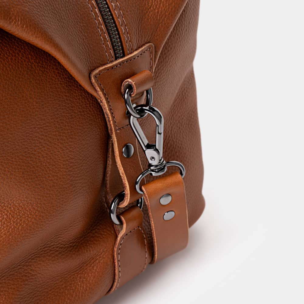 Close-up of cognac Legacy leather duffel bag shoulder strap hardware