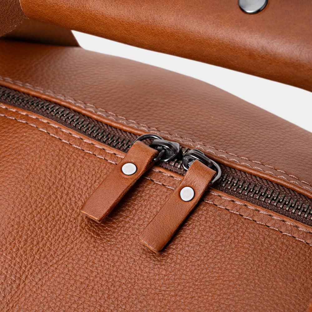 Close-up of cognac Legacy leather duffel bag top zipper pulls