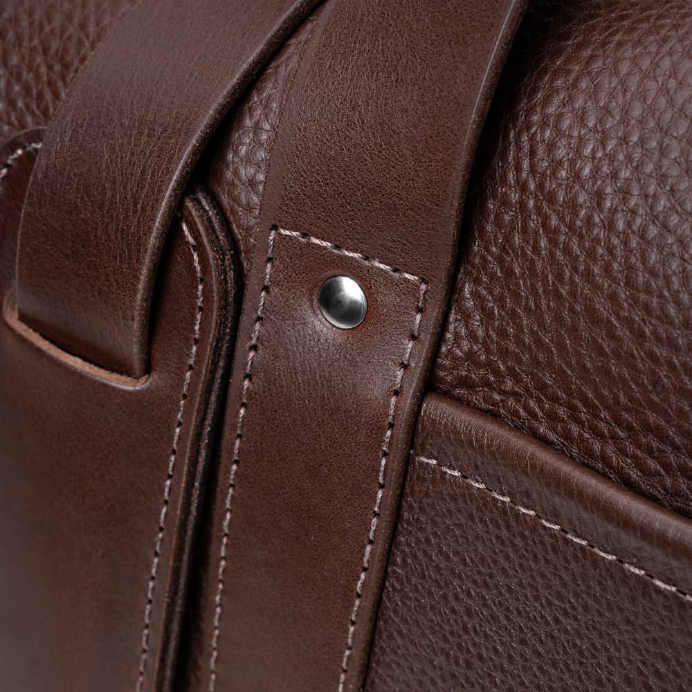 Close-up of espresso Legacy leather duffel bag handle attachment detail