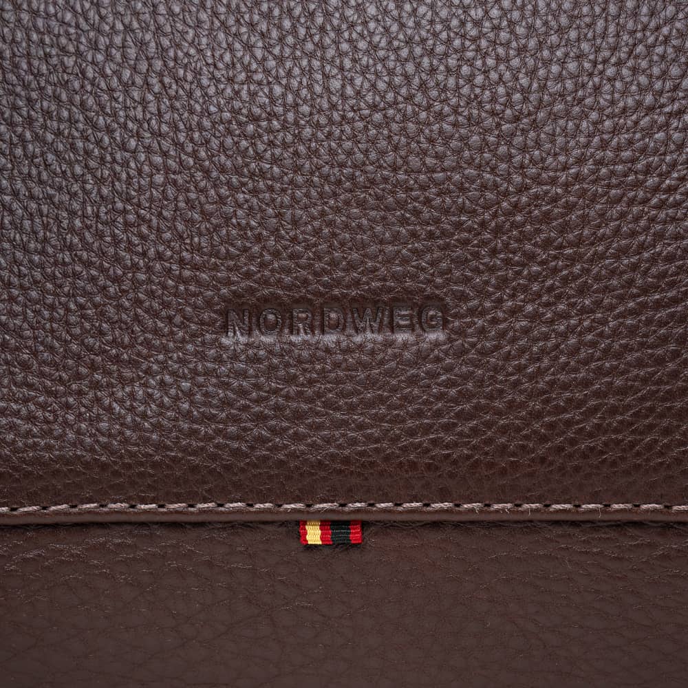 Close-up of Nordweg logo on espresso pebbled leather duffel bag