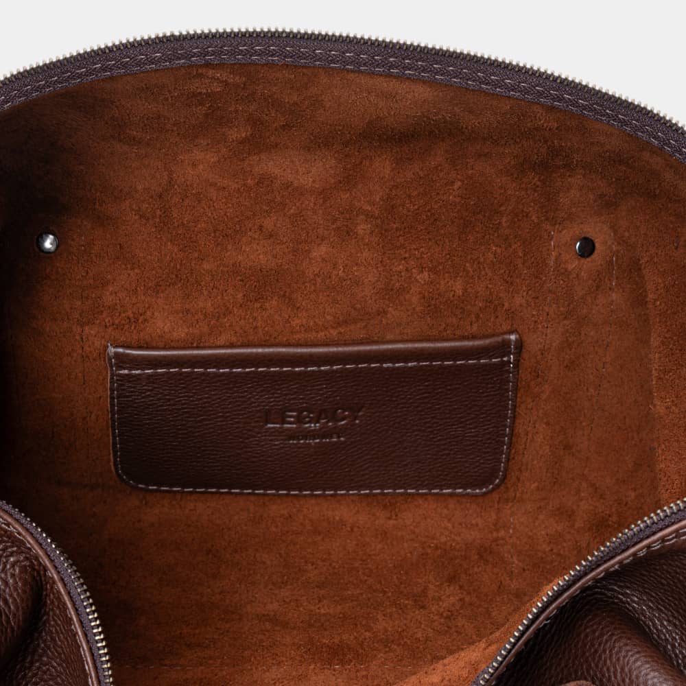 Open espresso Legacy leather duffel bag showing interior pocket