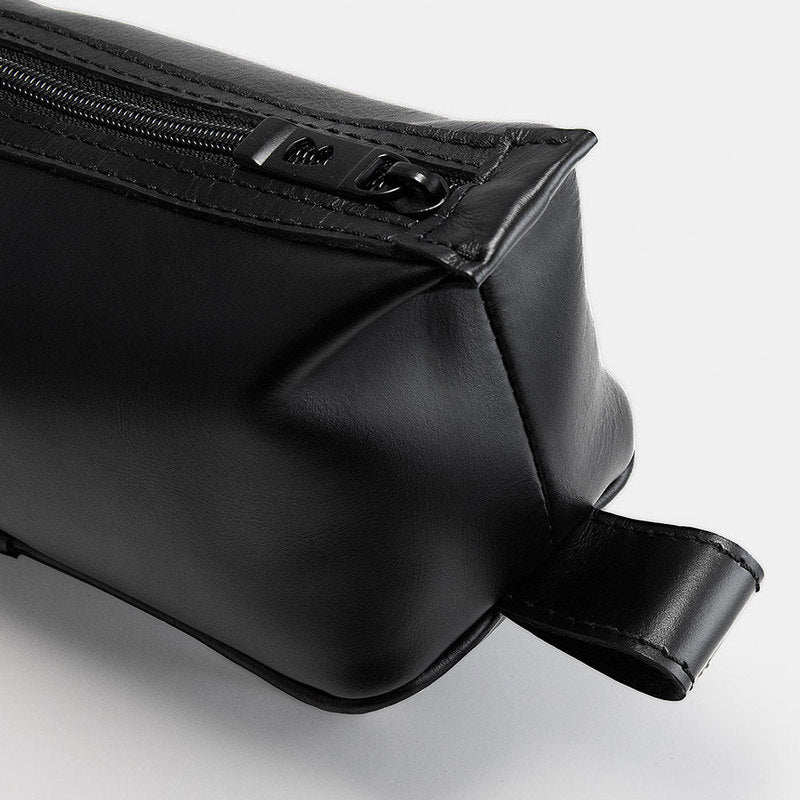 Close-up of black Nomad leather dopp kit hanging loop and zipper hardware