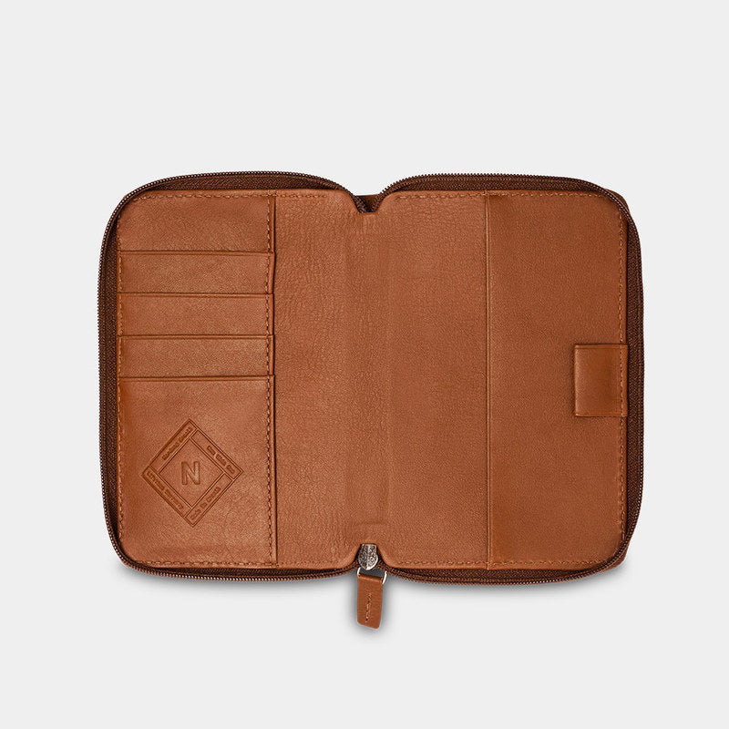 Open caramel Nomad leather passport wallet showing card slots and passport pocket