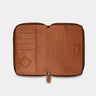 Open caramel Nomad leather passport wallet showing card slots and passport pocket