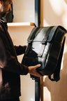 Black Nordweg Dolomites leather travel backpack held indoors during a product inspection, SKU NW101.IP