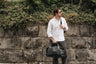 Coal Nordweg Legacy leather duffel bag carried by hand outdoors, SKU NWL002.CO