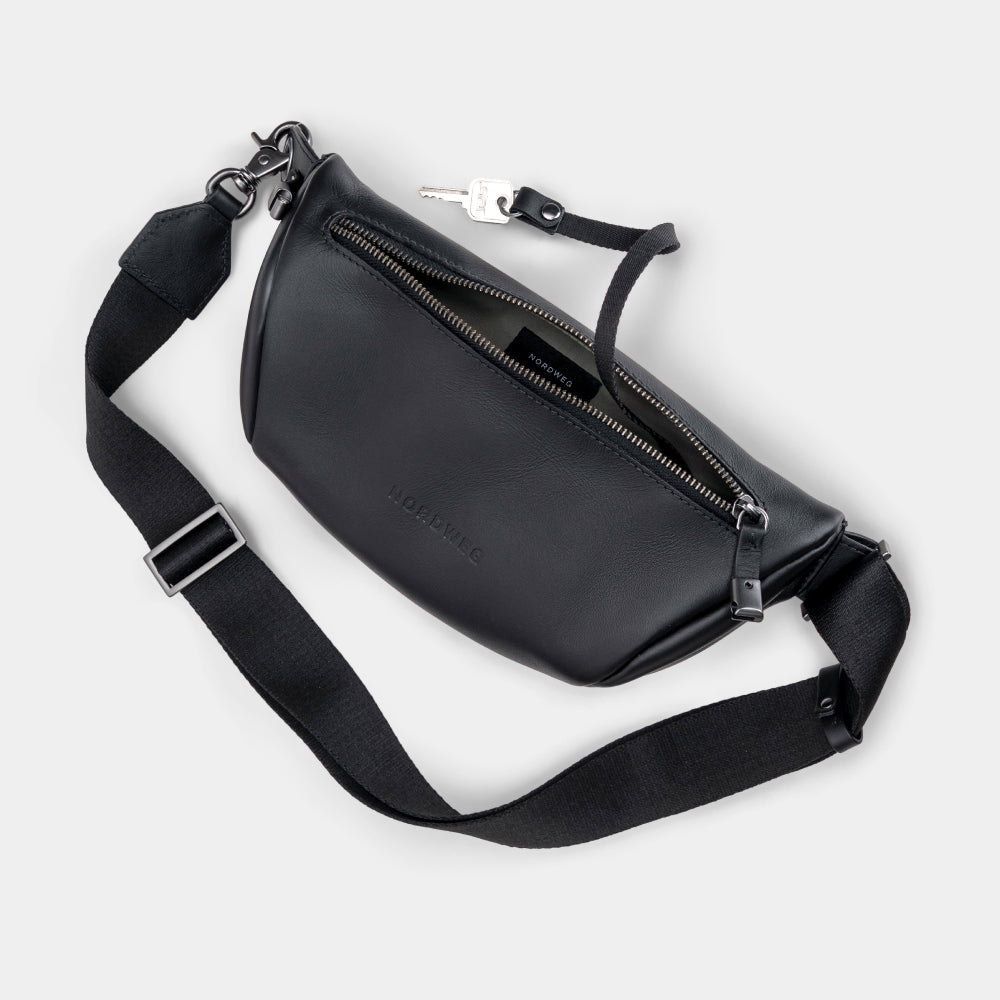 Black Pulse leather sling bag angled back view with strap and key detail