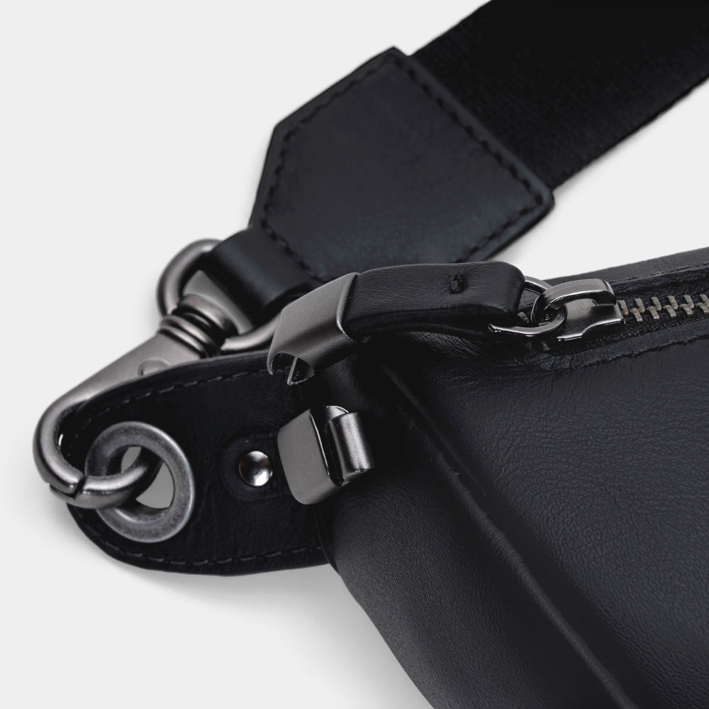 Close-up of black Pulse leather sling bag zipper lock and hardware detail