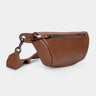 Nordweg Pulse leather sling crossbody bag in caramel, angled front view with strap and key tag