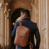 Man wearing the Caramel Slim Workplace leather laptop backpack in Paris, rear view