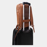Caramel Slim Workplace backpack secured over a rolling suitcase handle