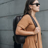 Woman wearing the Coffee Slim Workplace leather laptop backpack, side view