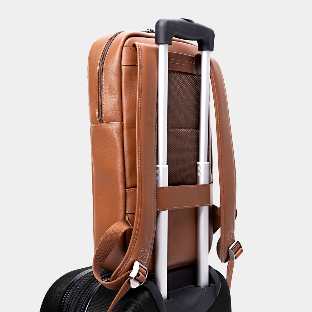 Caramel Nordweg Slim Workplace leather laptop backpack secured on a rolling suitcase handle