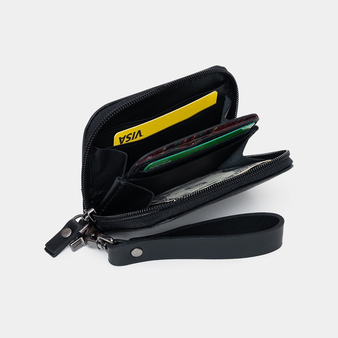 Open black Traveler Pro AirTag leather wallet showing card slots, cash, and zip pocket