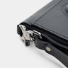 Close-up of black Traveler Pro AirTag leather wallet wrist strap and zipper attachment