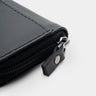 Close-up of black Traveler Pro AirTag leather wallet zipper pull and closure detail