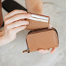 Caramel Traveler Pro AirTag wallet mini cardholder shown in hand with cards