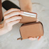 Nordweg Traveler Pro AirTag leather wallet in Caramel with mini cardholder and cards shown in hand