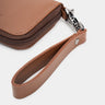 Close-up of caramel Traveler Pro AirTag leather wallet wrist strap and zipper attachment