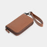 Caramel Nordweg Traveler Pro AirTag leather wallet, angled view with wrist strap