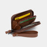 Open caramel Traveler Pro leather zip wallet showing card slots, cash pocket, and wrist strap