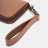 Close-up of the wrist strap and zipper hardware on the Nordweg Traveler Pro Wallet in Caramel.